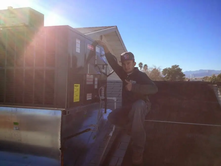 HVAC technician performing Air Duct Repair on a rooftop unit in Meadville